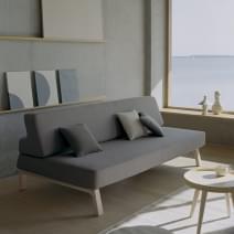 Apartamento tipo estudio con sofá cama plegable, armario y mesa de comedor  plegable blanca con sillas a juego y jarrón con flores de imitación